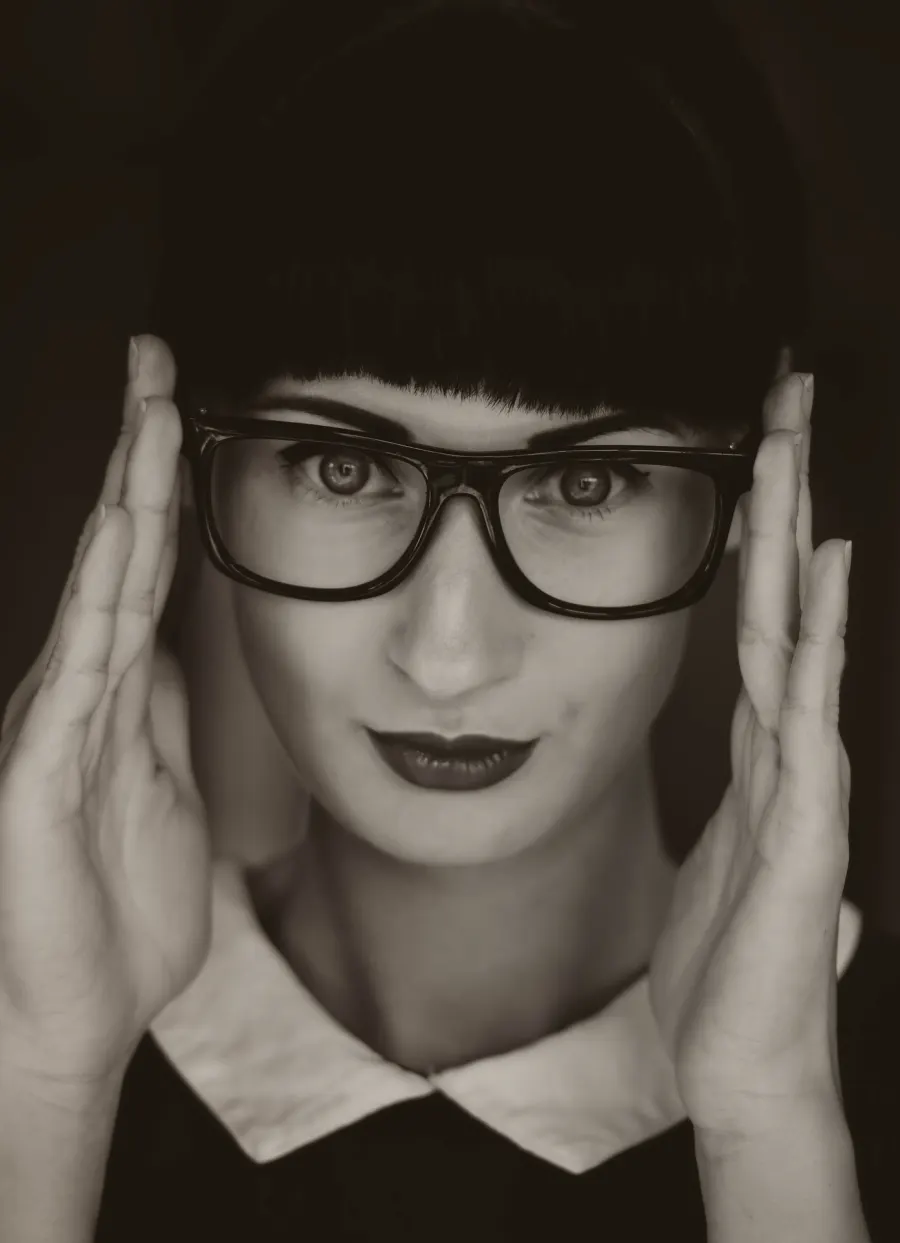 Woman adjusting her glasses, illustrating Optikals AR eyewear try-on